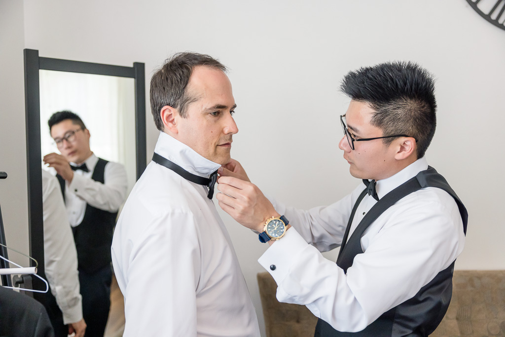 groomsmen putting on bow tie