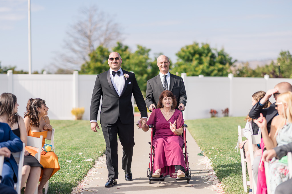 parents of the groom in wheelchair during wedding processional