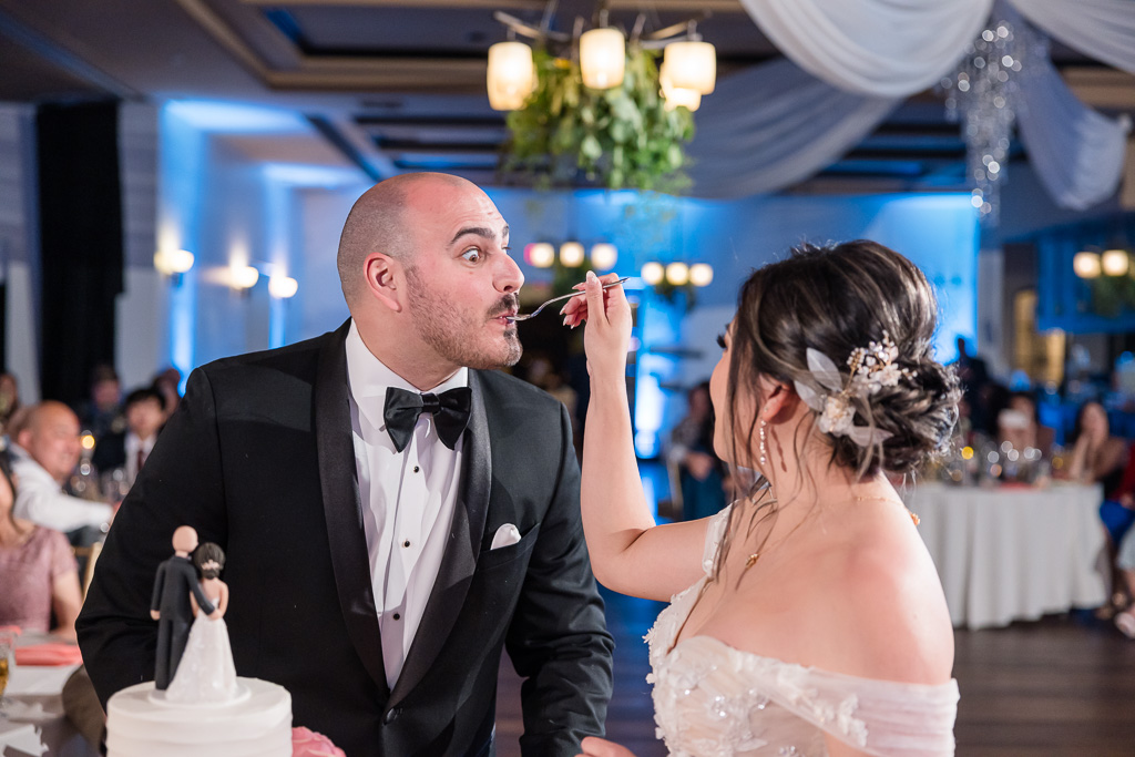 funny photo of bride feeding the groom cake