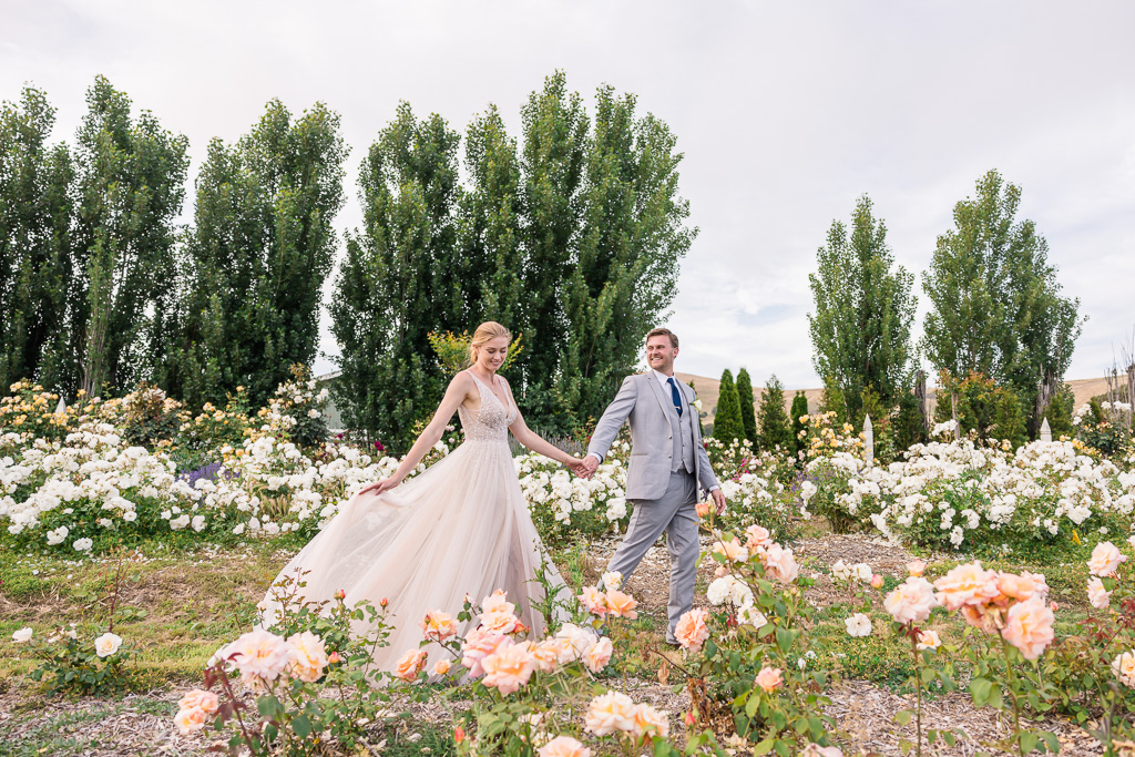 candid wedding portraits in pastel colored rose garden