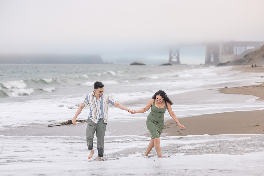 romantic photo of couple walking through ocean water
