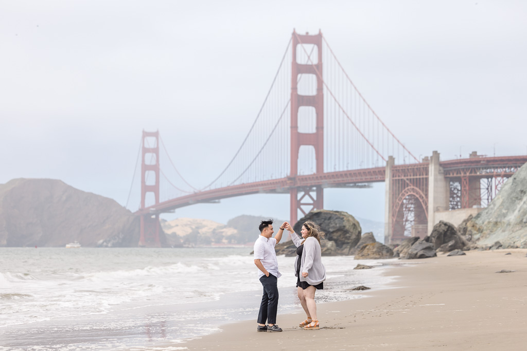 dancing on the beach engagement photos at the Golden Gate Bridge