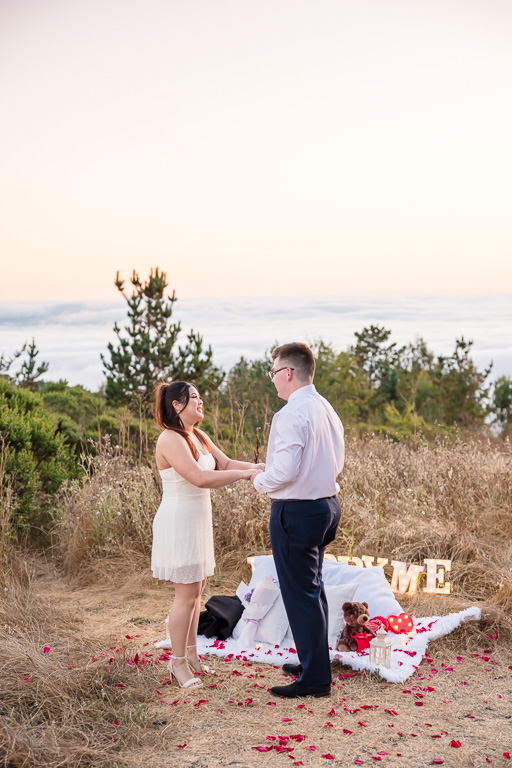 surprise proposal over a sea of fog underneath