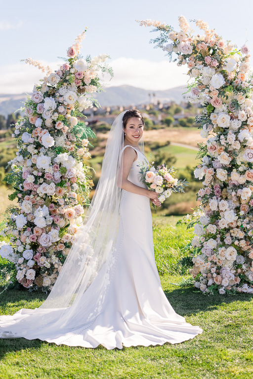 bridal solo in front of split floral arch