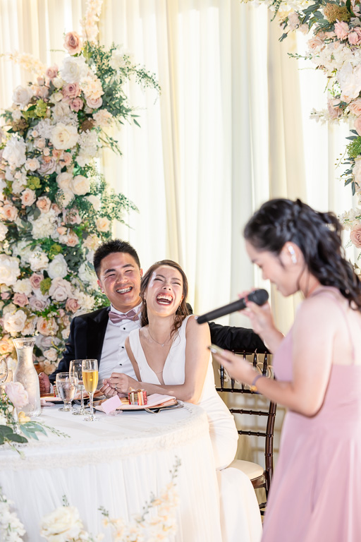 bride and groom laughing during dinner toasts