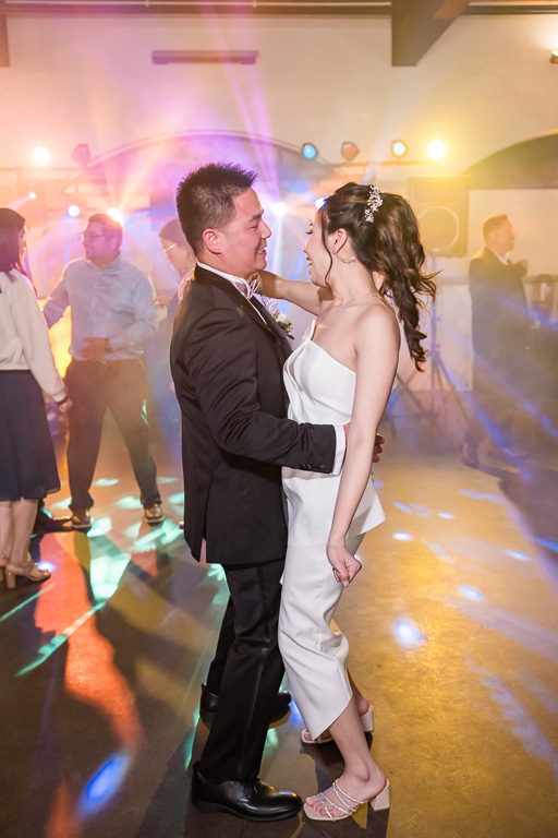 bride and groom dancing with colored lights and fog