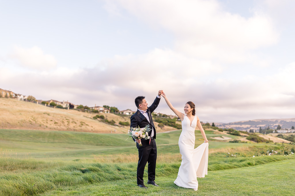 bride and groom dancing on golf course at sunset