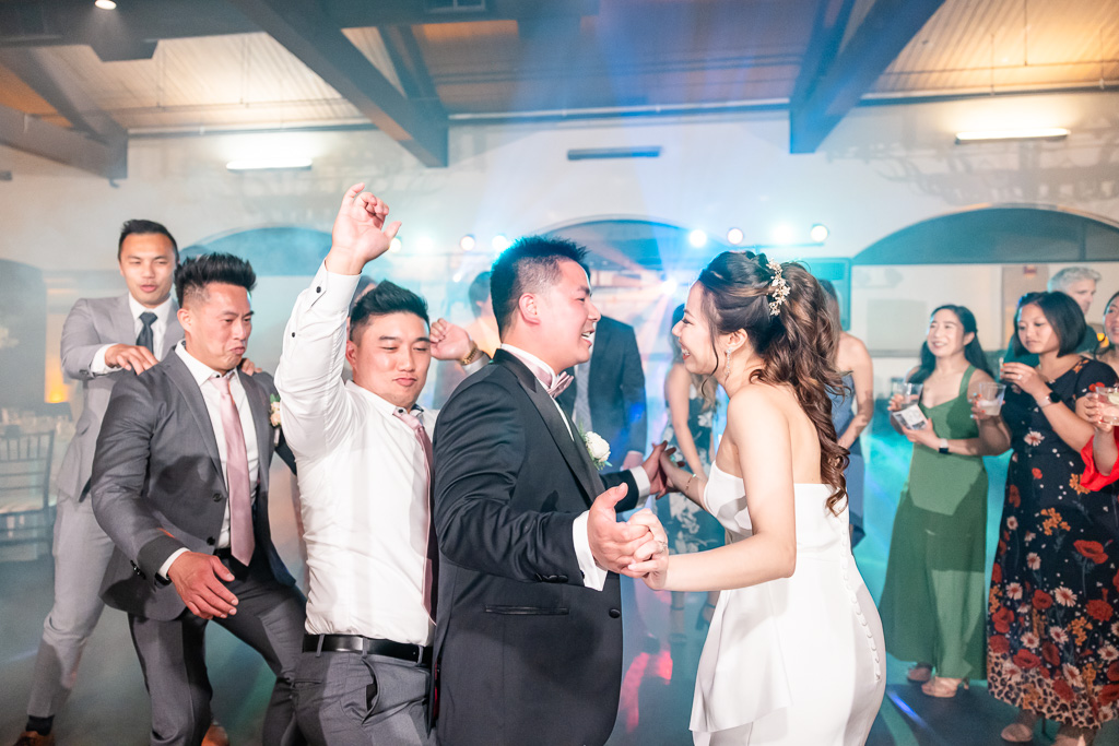 newlyweds and friends dancing