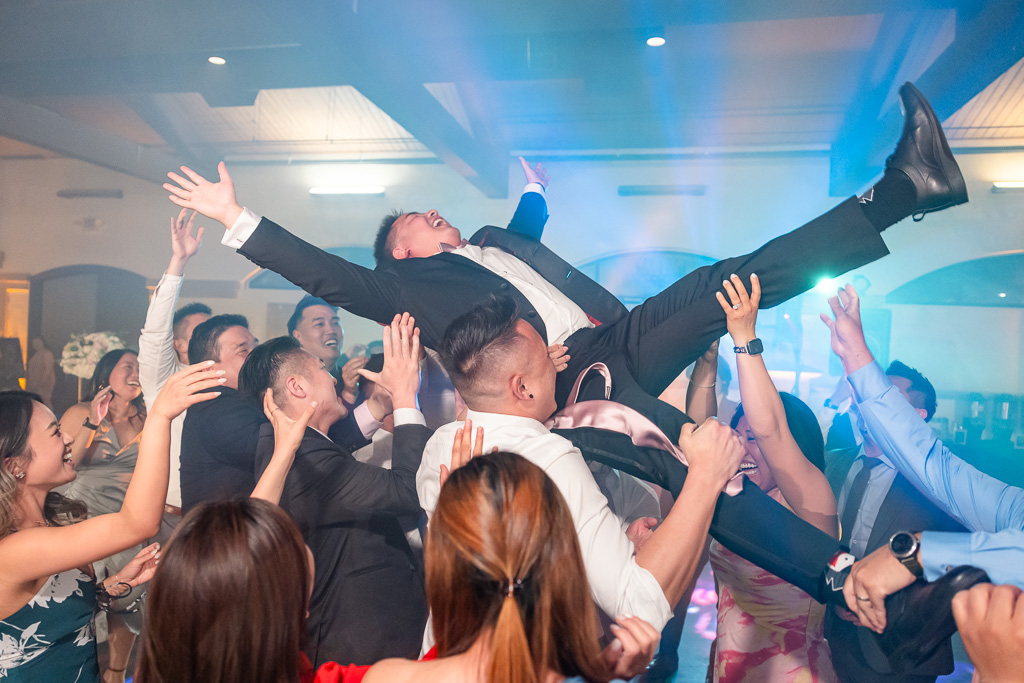 groom being picked up and crowd-surfing at wedding reception