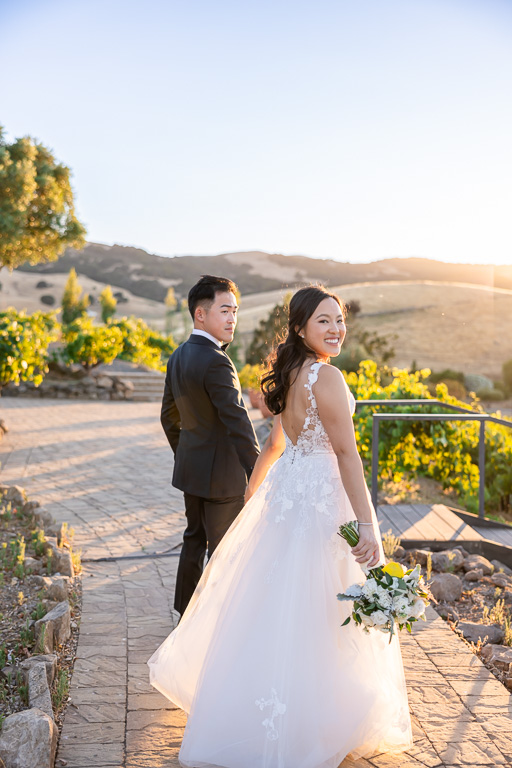 bride and groom walking during sunset photo