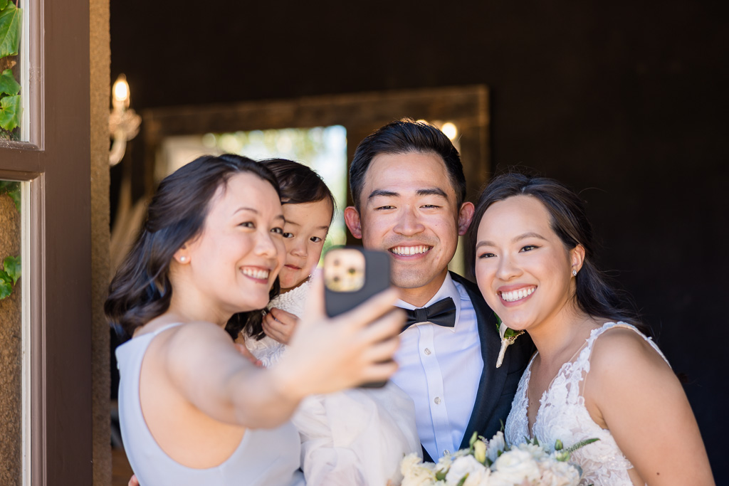 guests taking a selfie with the bride and groom