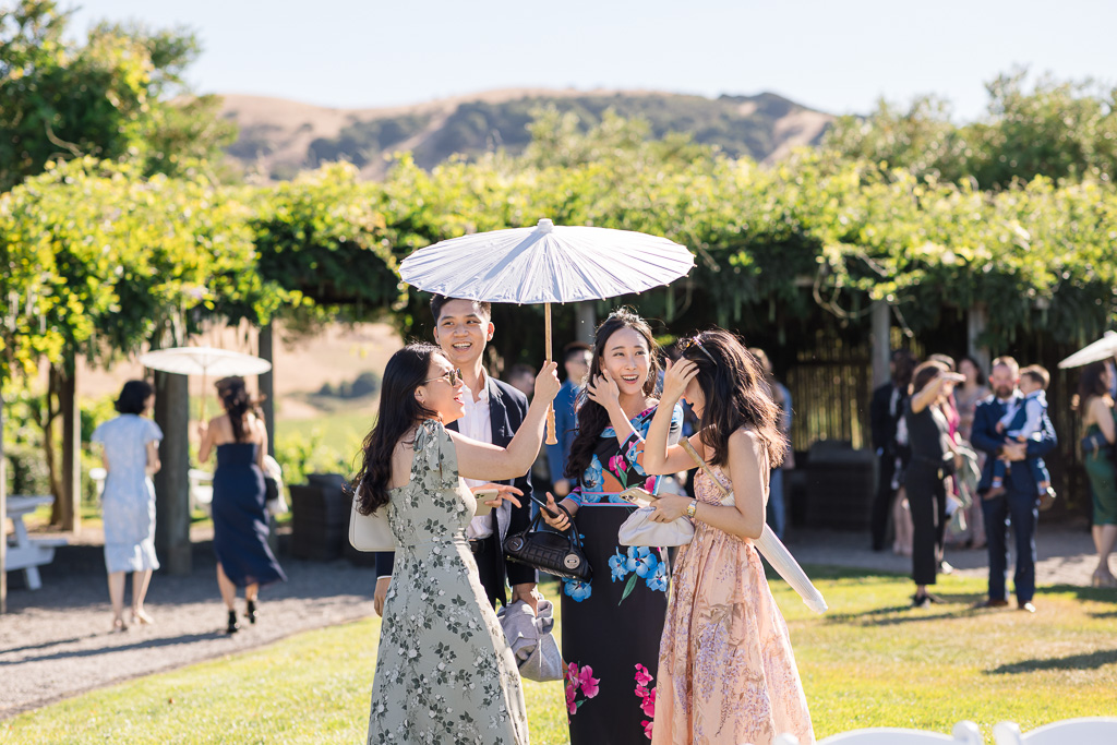 wedding guests under a parasol