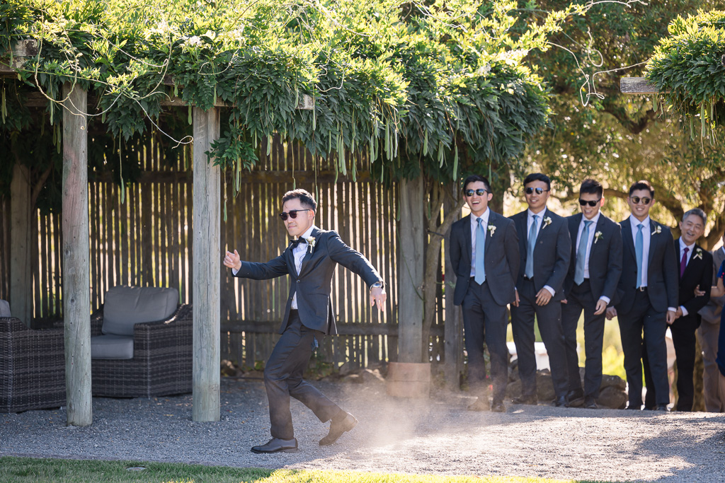 groom kicking up dust as he dances into the ceremony