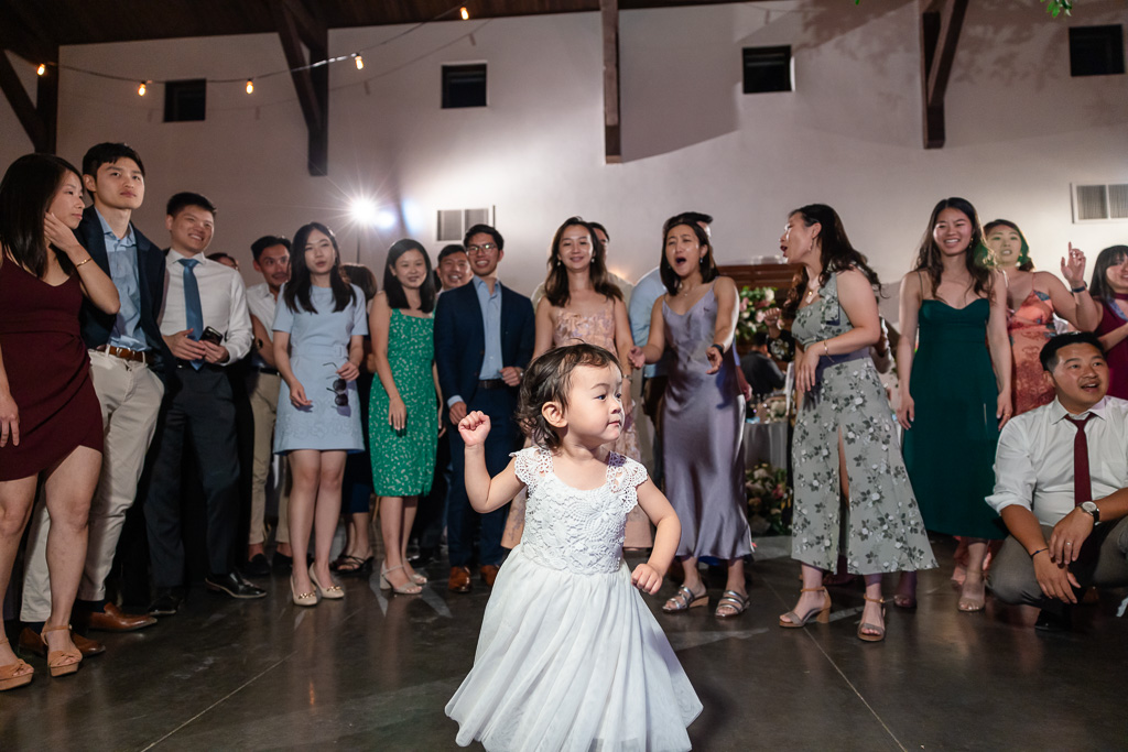 little baby rocking the dance floor while adults gather in a circle to watch