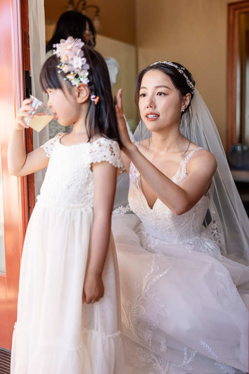 bride helping flower girl with her hair
