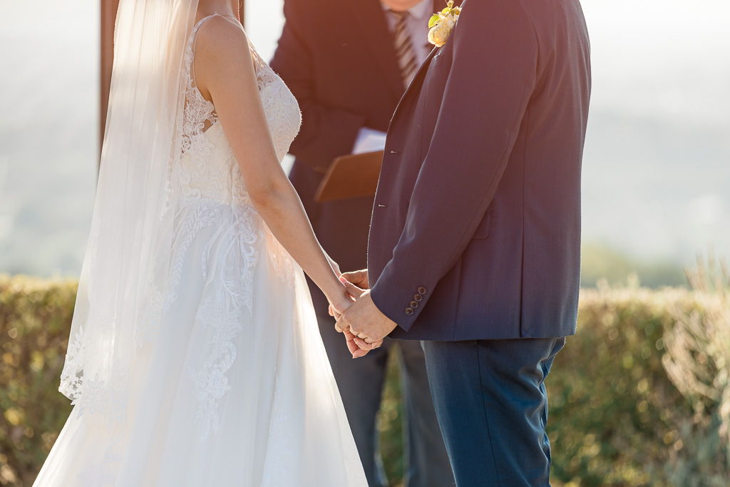 holding hands during sunset wedding ceremony