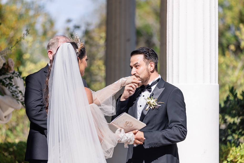 groom kisses wife's hand after his vows
