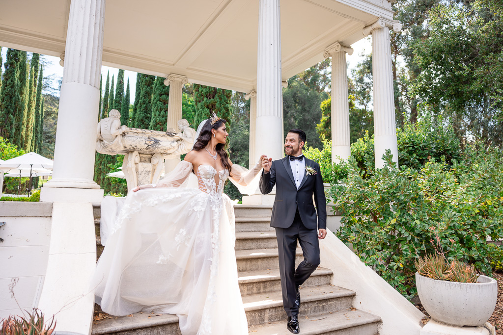 groom leading bride walking in her royal gown and veil