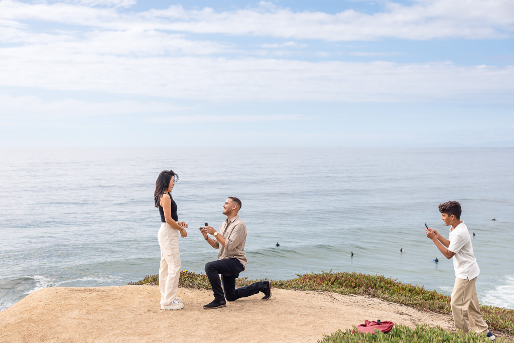 son helping to take proposal photos of mom and dad