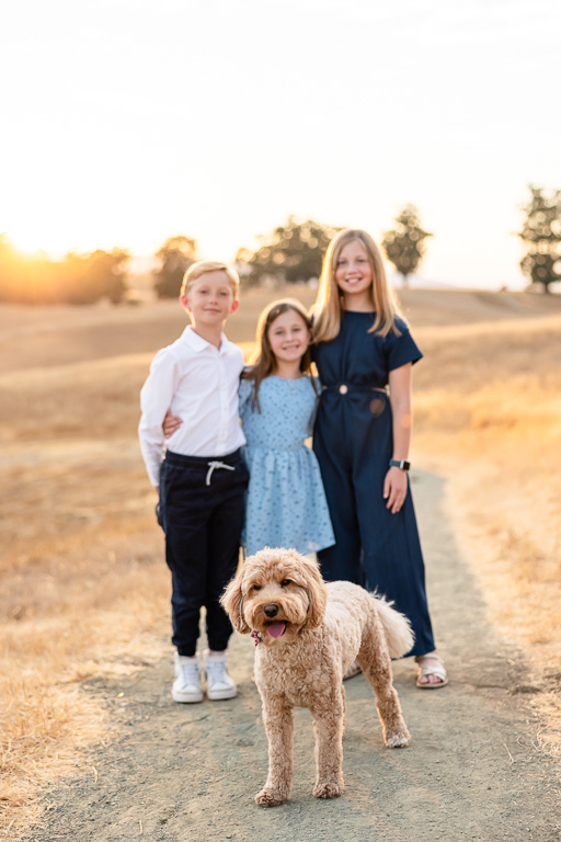 family photo with three kids and their dog