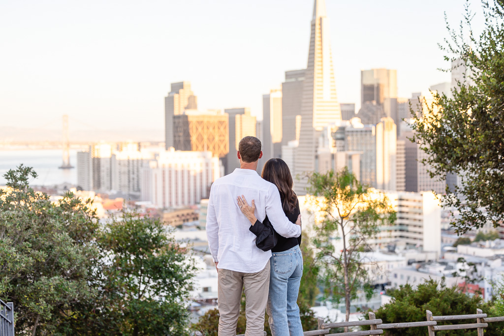 engagement photo of couple looking at downtown San Francisco during sunset