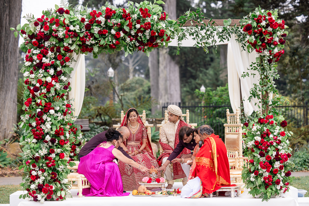 bride and groom with parents under mandap