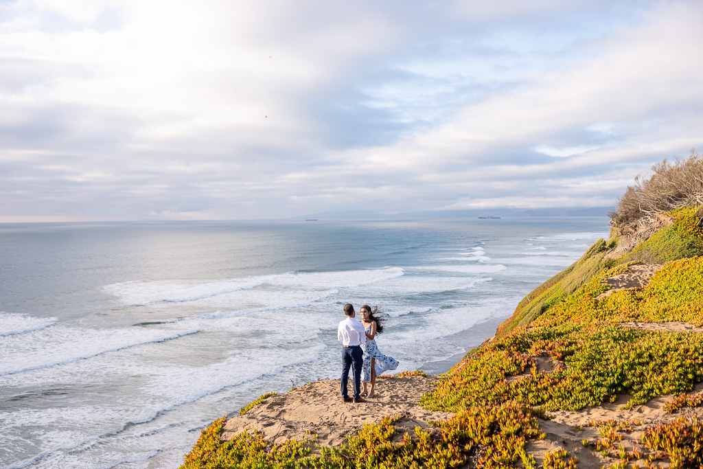 couple standing on an ocean cliff at the end of the world