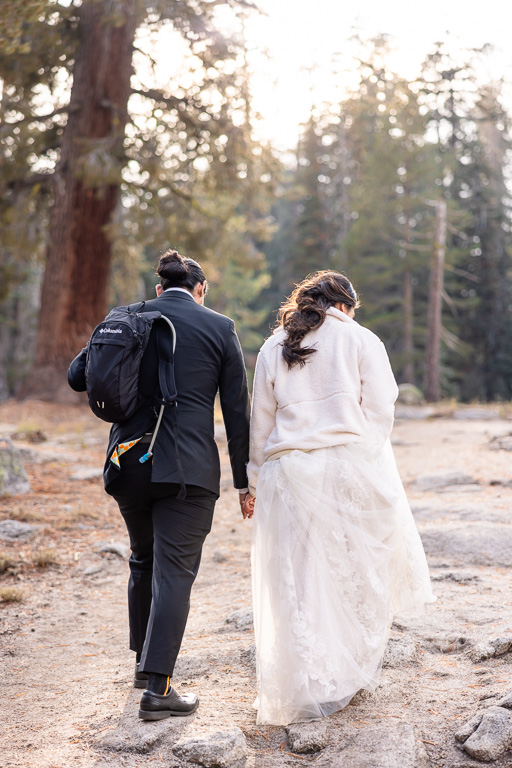 couple hiking in Yosemite in wedding attire