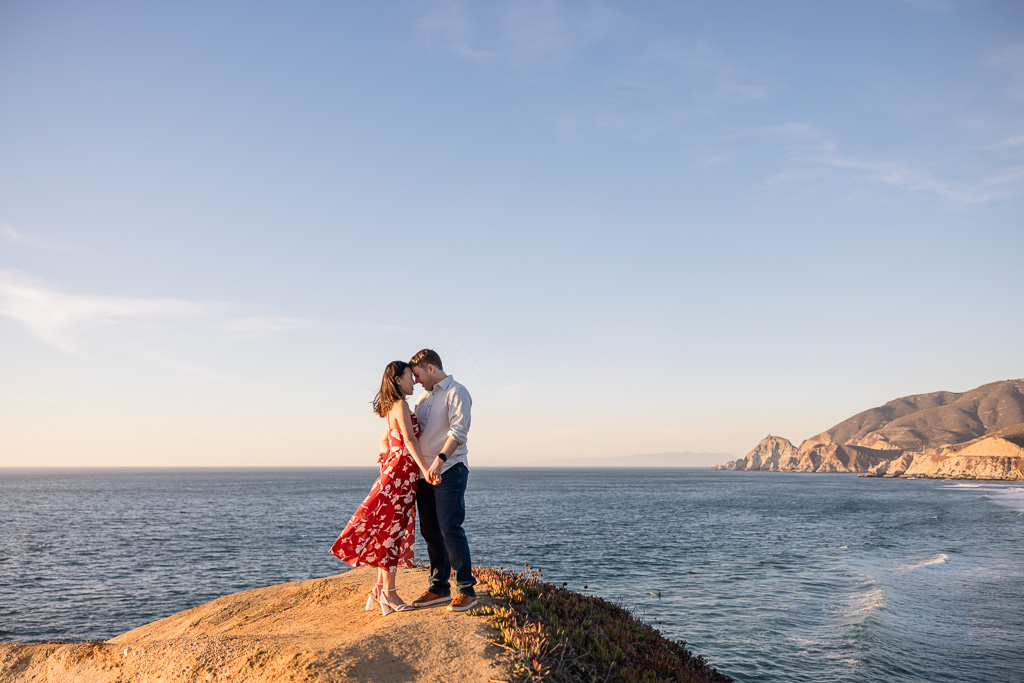 engagement photos on a hilltop overlooking the ocean