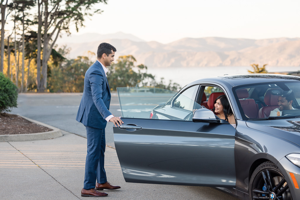 groom receiving bride out of car for surprise proposal