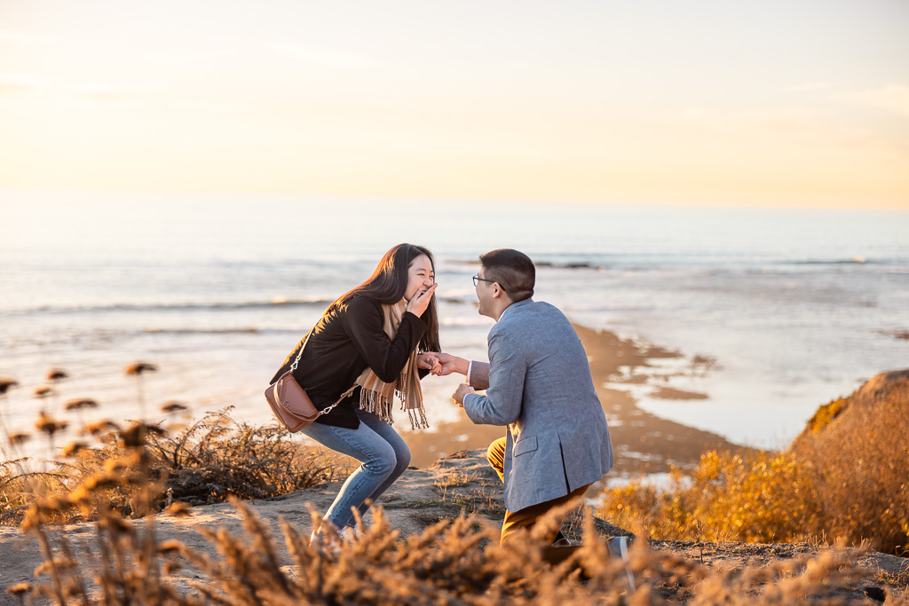 surprised and happy reaction to marriage proposal by the ocean