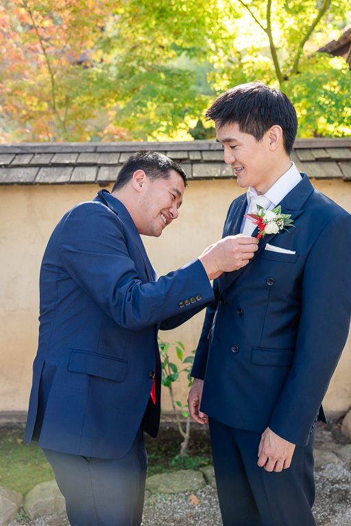 best man helping groom with boutonniere