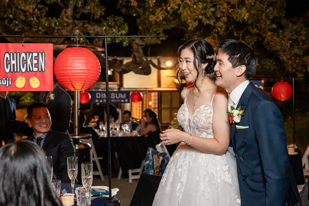 bride and groom walking around night market themed reception tables to greet guests