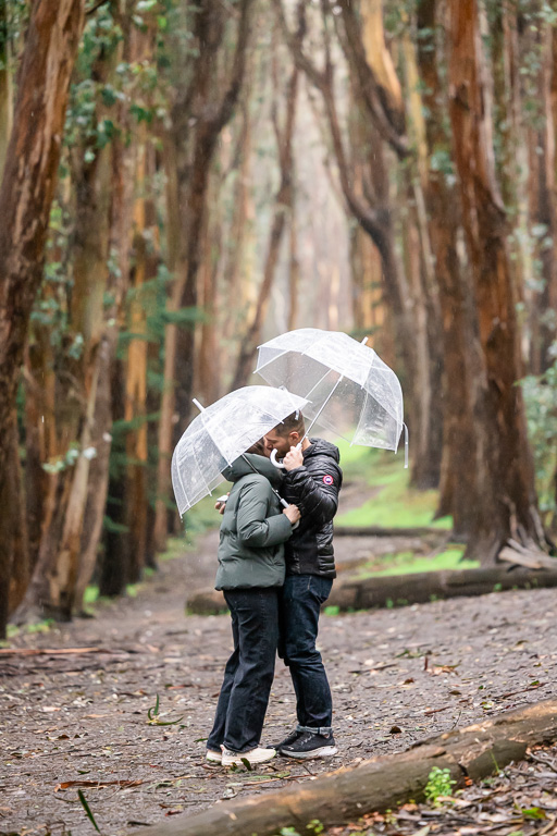 couple hugging in the rain with umbrellas