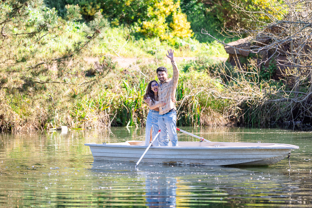 couple standing in a boat waving