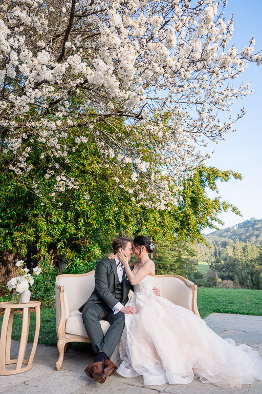 sunset photo of bride & groom sitting on a couch outside The Brazilian Room