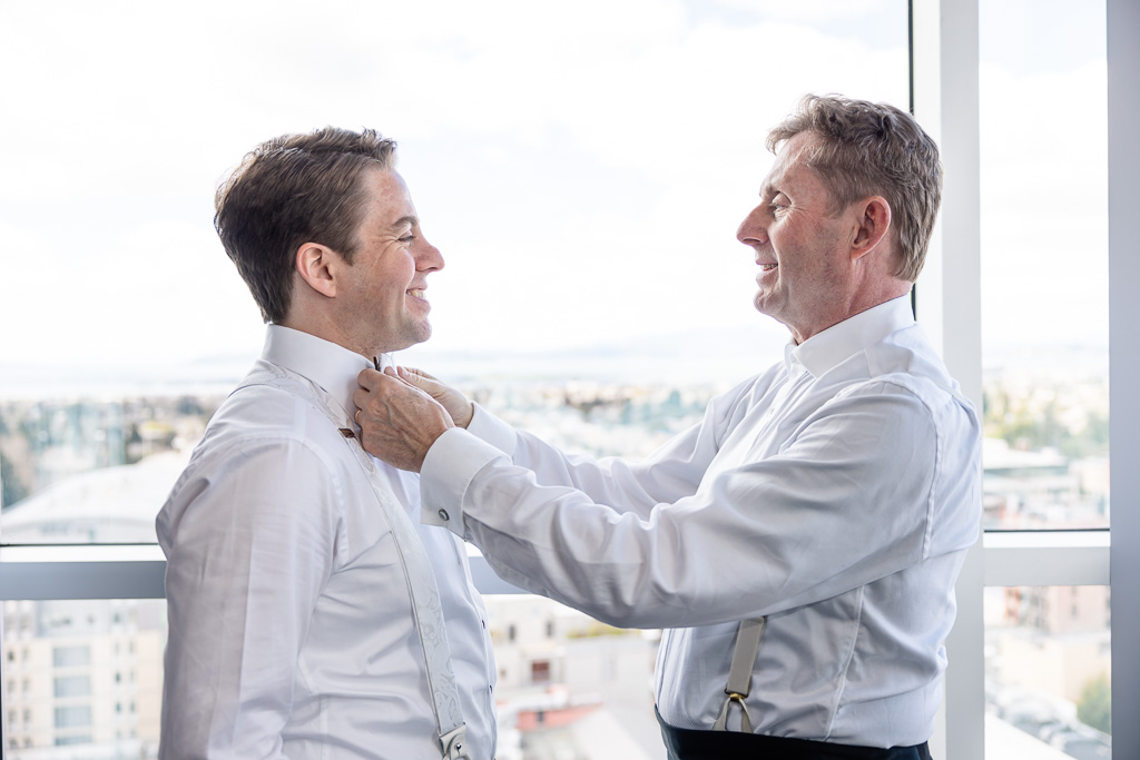 dad helping groom get ready during wedding prep