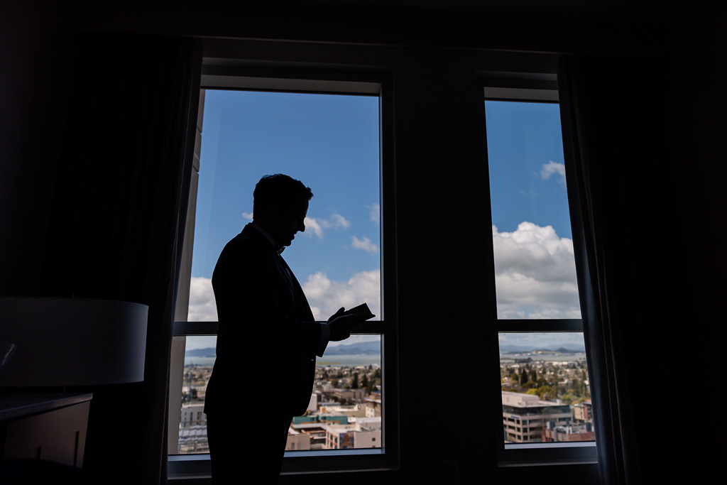 creative silhouette photo of groom reading his vow book