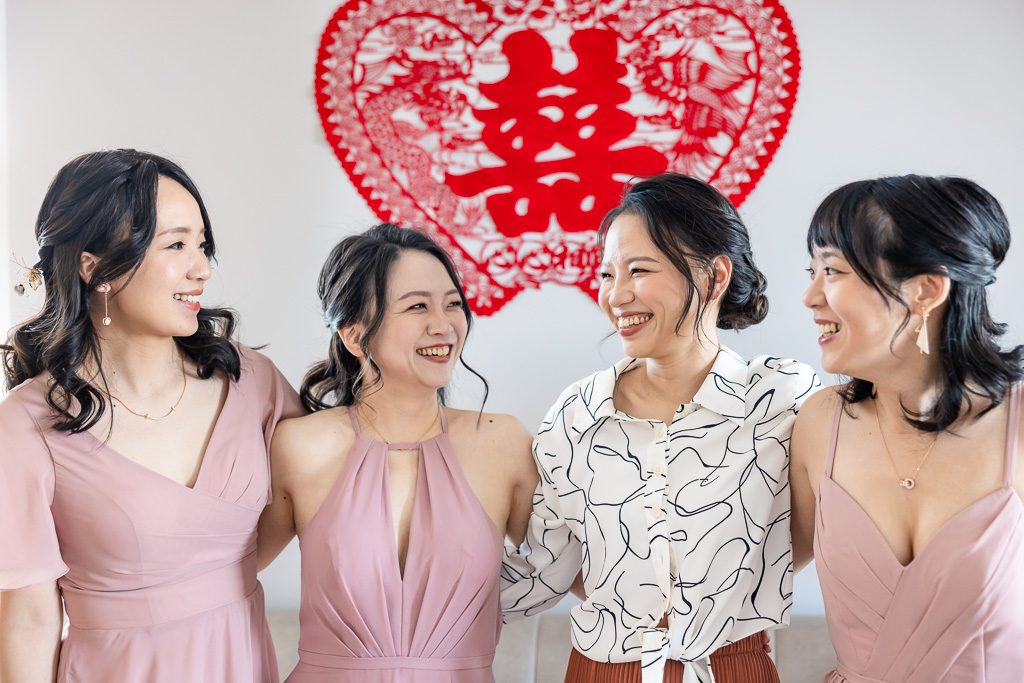 bride and bridesmaids in front of red Chinese decor