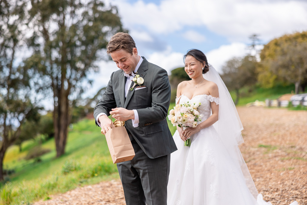 groom opening up his gift from bride