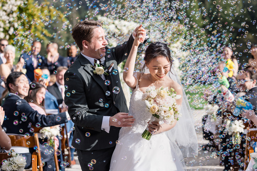 bride & groom dancing through bubbles on their recessional out of the wedding ceremony