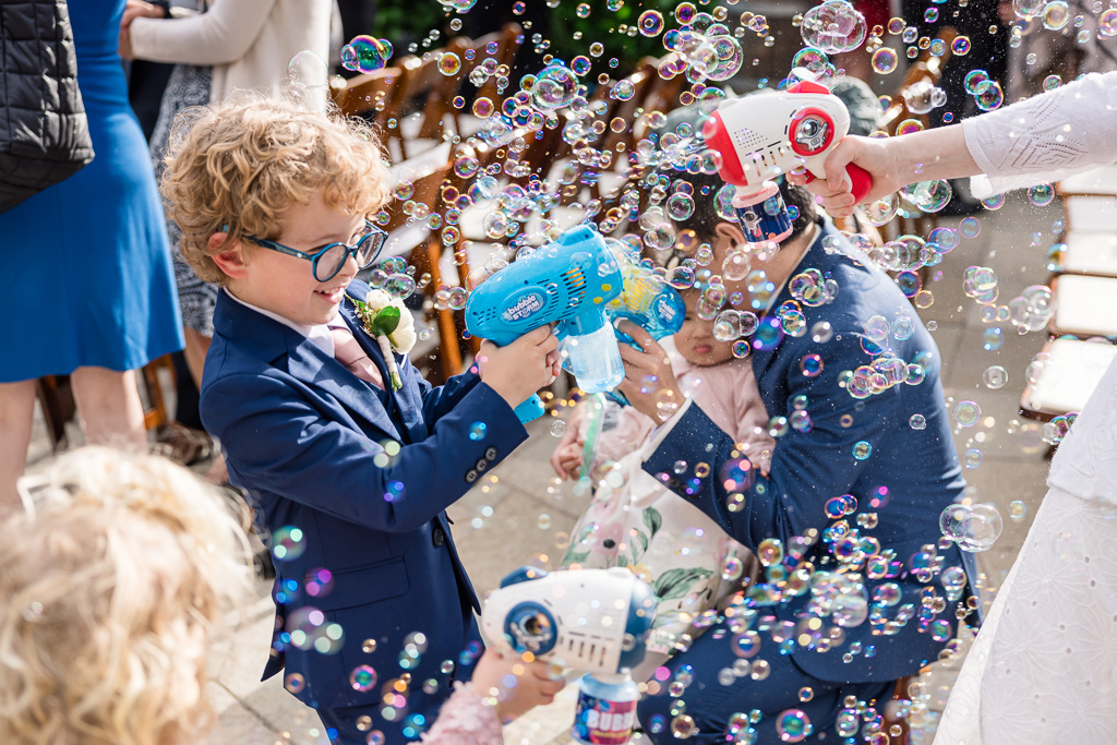 kid blowing bubbles with bubble gun