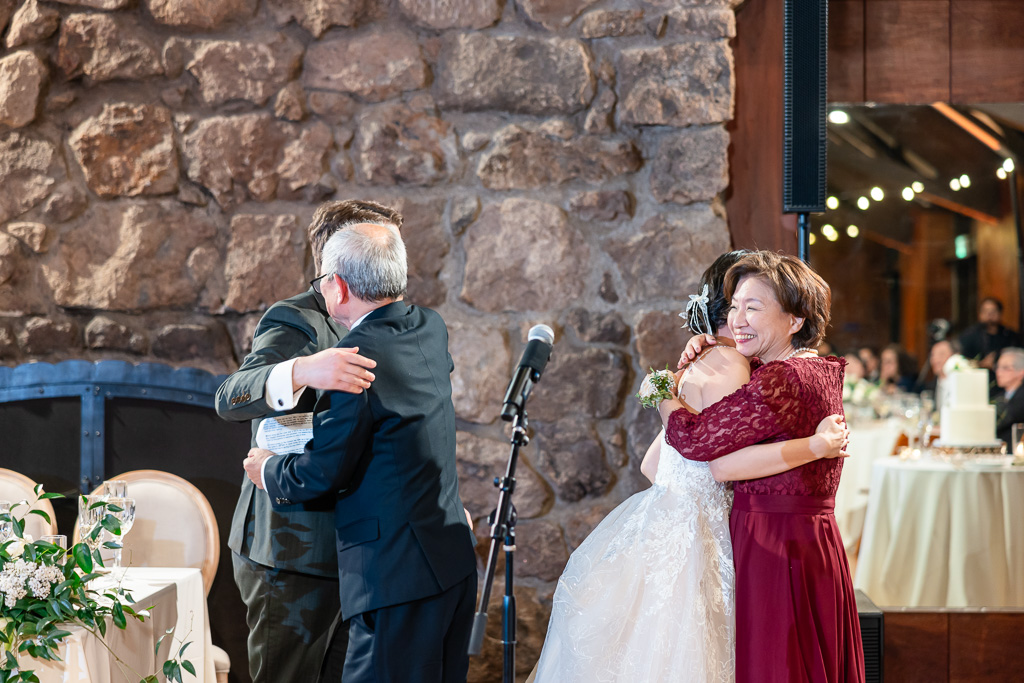 double hug between bride and groom and parents