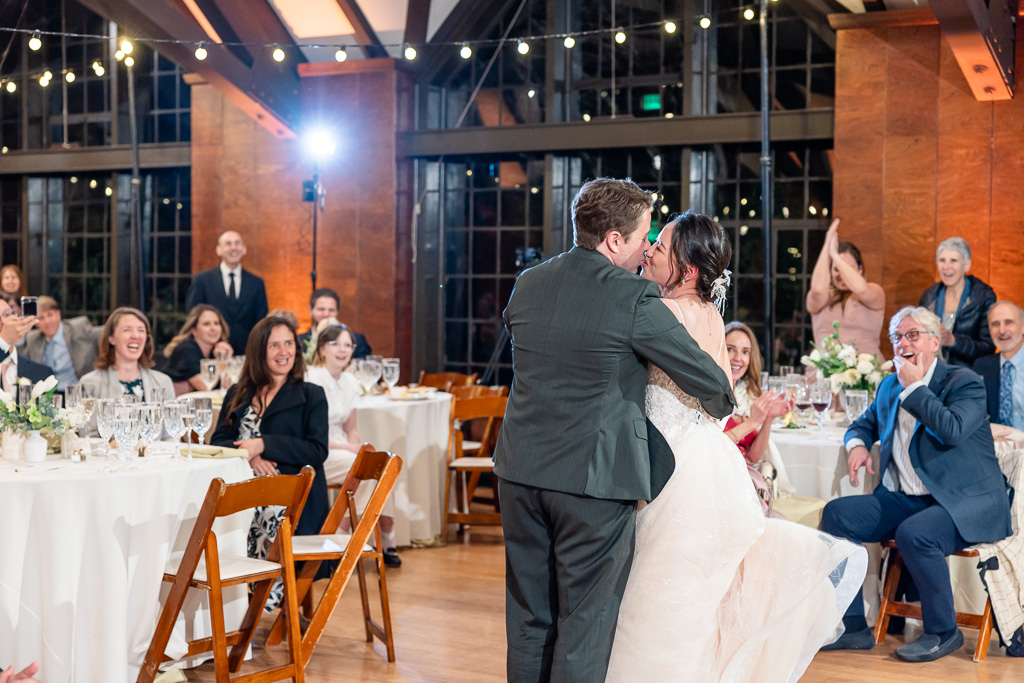 a kiss between the bride & groom as guests look on