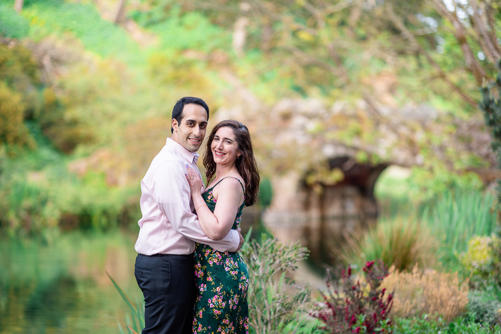 Stow Lake engagement photos with stone arch bridge in the background