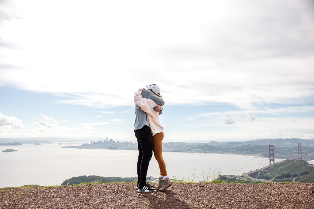 a hug after proposal on a hill hike