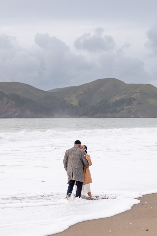 romantic photo of couple knee-deep in water at the beach