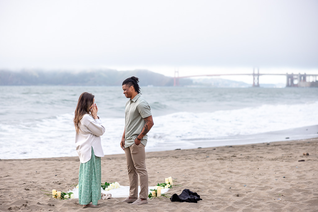 surprise proposal picnic blanket on beach