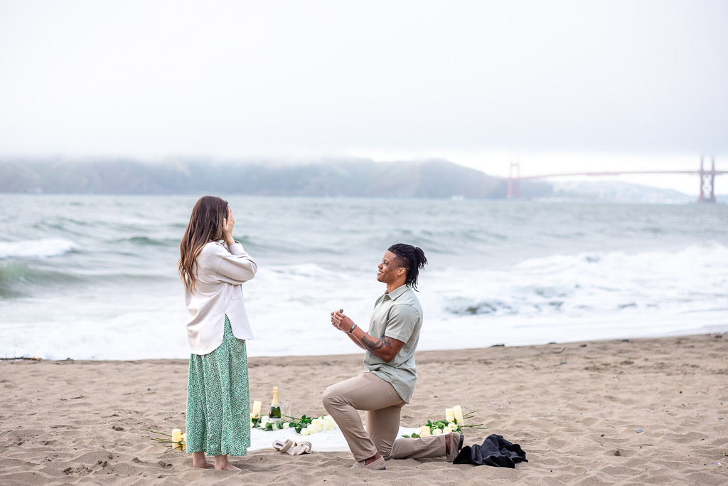 China Beach surprise proposal with picnic blanket and candles