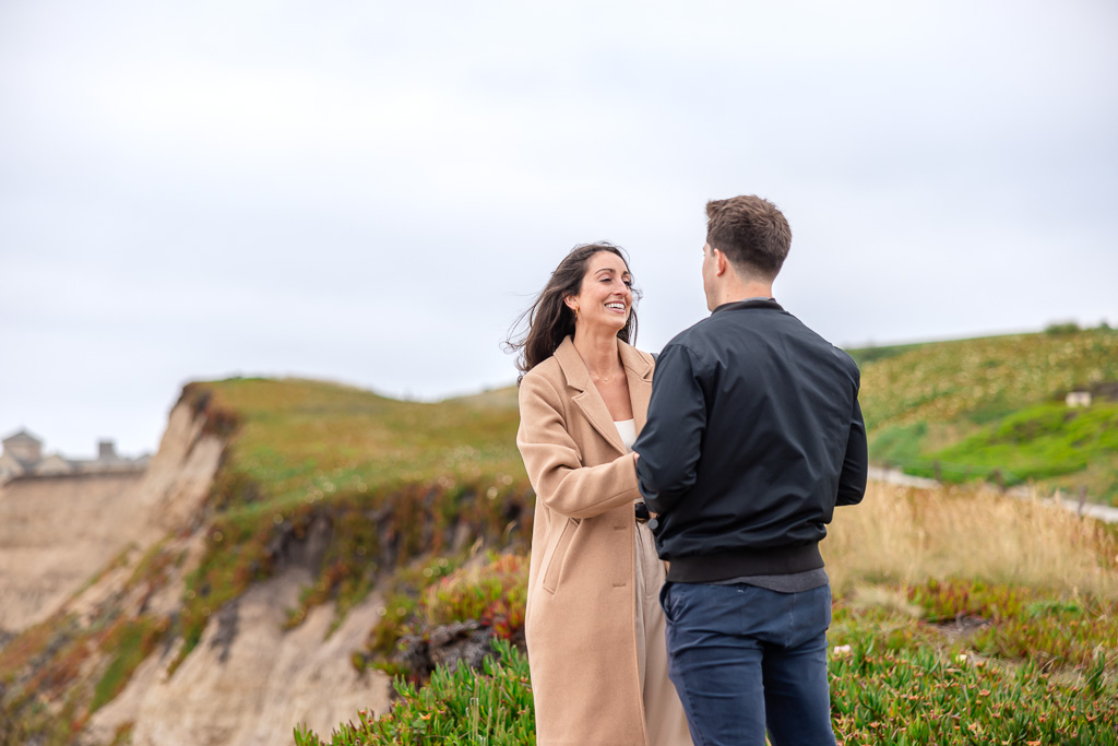 couple standing on a cliffside coastal trail